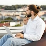 Man working on laptop outdoors on a rooftop terrace