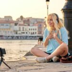 Teenage female blogger recording video content, talking to followers using smartphone